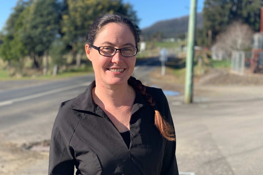 Rachel Power, a cafe owner, smiles in the street