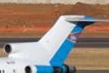 A Hewa Bora plane sits on a runway