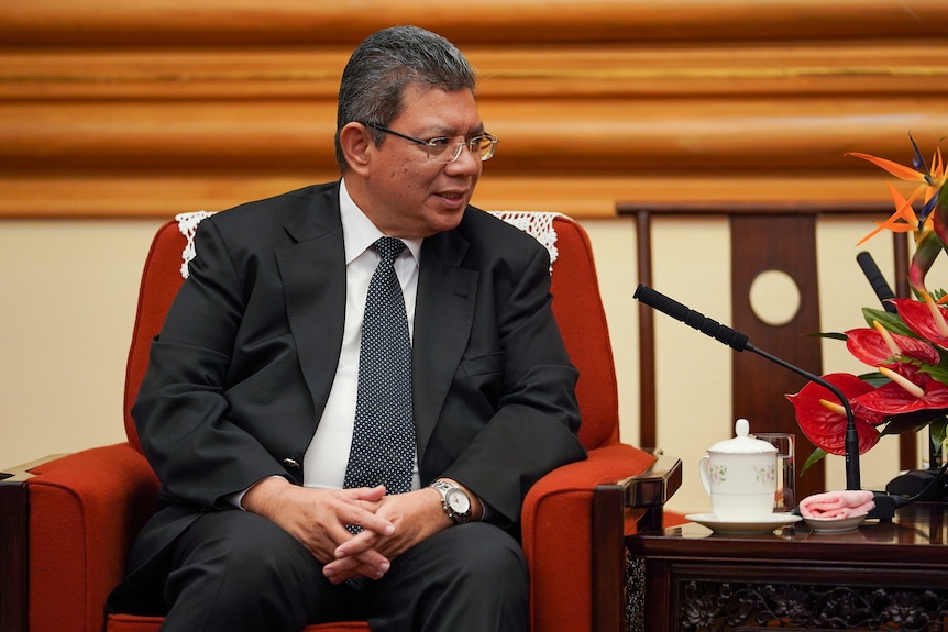 Saifuddin Abdullah sits and speaks to a member of China's Politburo in Beijing