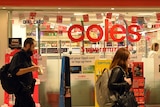 Office workers walk past a Coles supermarket.
