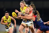 Ashleigh Woodland is tackled by two Melbourne defenders