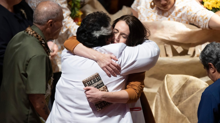 Prime Minister Jacinda Ardern is hugged during a ceremony in Auckland