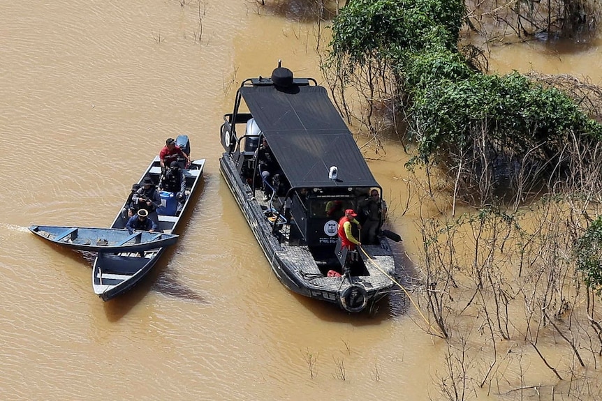 深棕色河流，三艘船载人在船上寻找失踪人员