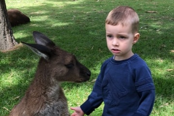 Mitchell Fielke stands next to a small wallaby