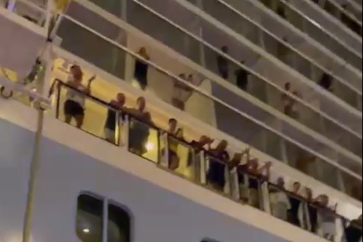 Скриншот видео: люди на балконах круизного лайнера аплодируют