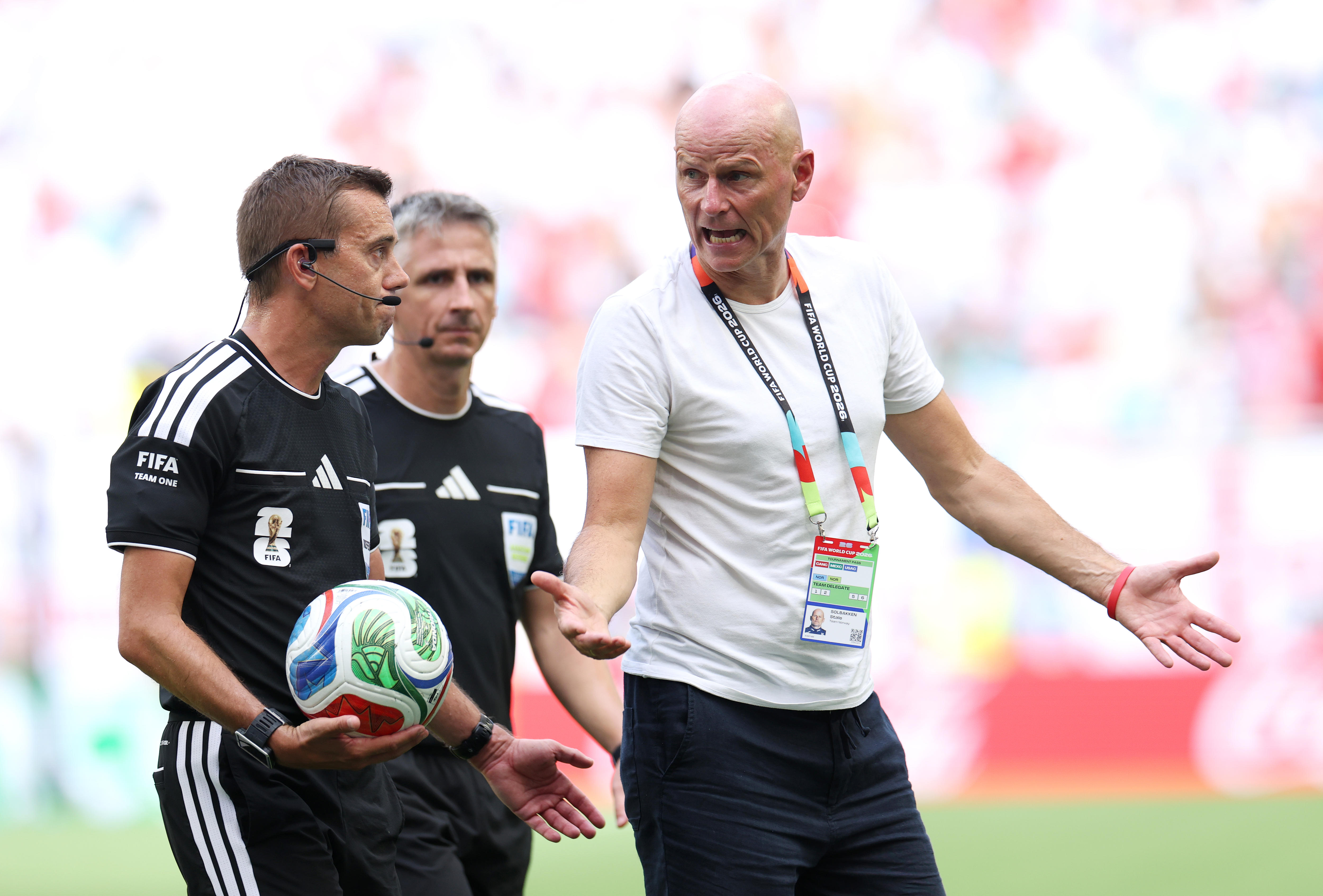 Norway coach Stale Solbokken argues with two referees.