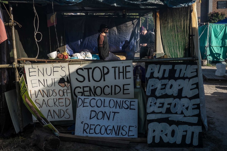 Protest signs double as walls on the makeshift shelter.