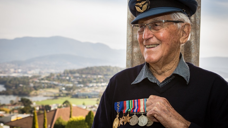 Brian Winspear AM in his home with six medals for his service.