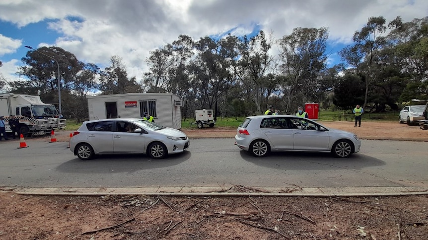 Cars at a checkpoint that is manned by police.