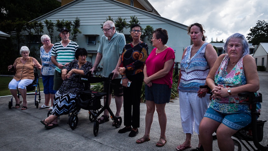 Nine residents form a line at their unit complex they've been asked to leave