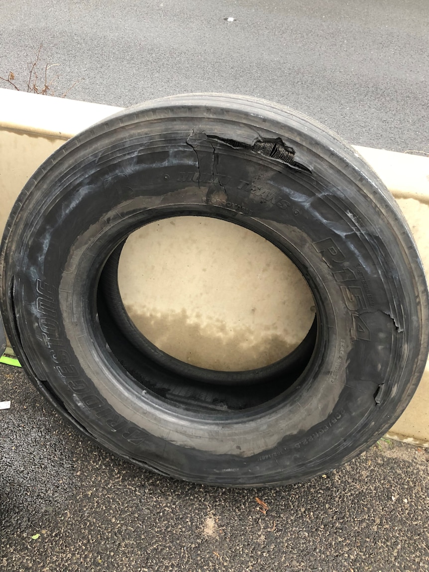 A torn truck tyre lying on the ground.