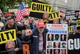 A mass of protesters carrying signs that say "guilty".