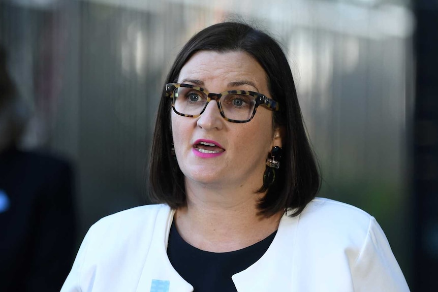 a woman in glasses at a press conference