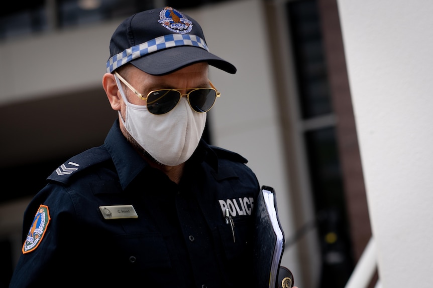 a male, masked police officer exiting court