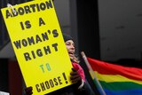 An anti-Donald Trump demonstrator holds a sign at a protest reading: "Abortion is a woman's right to choose!"