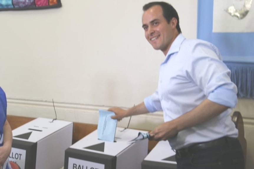 Liberal Vincent Tarzia puts his voting paper into a ballot box.