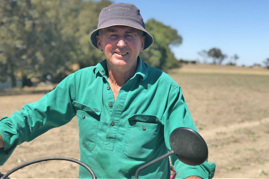 geoff sits on a two-wheeled motor bike in the middle of a paddock