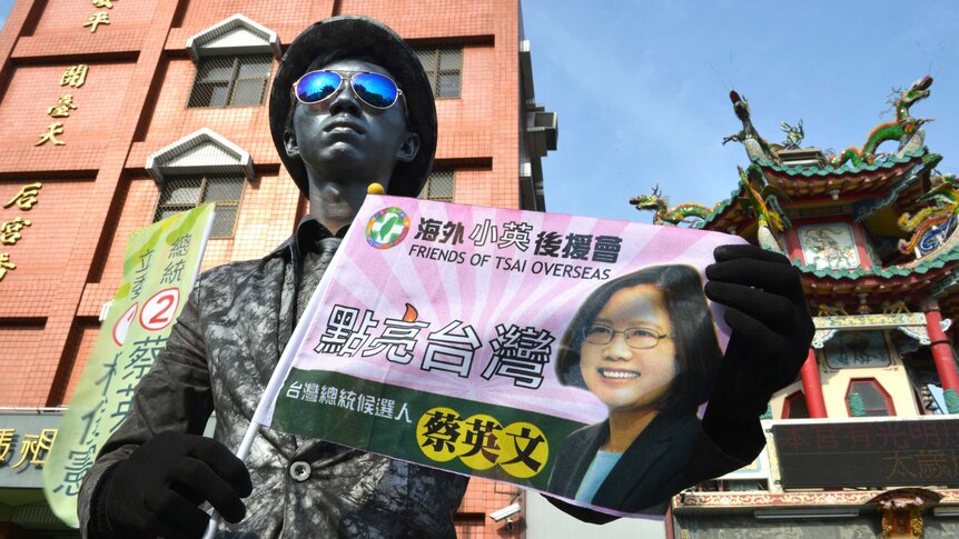 A street artist displays a campaign flag of Taiwan's Tsai Ing-wen