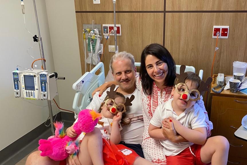 A family sits in a hospital bed.