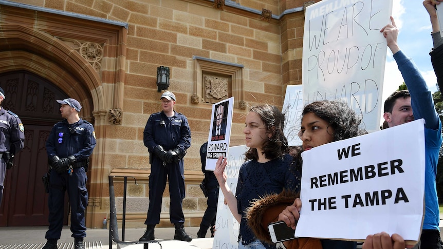 People hold 'we remember Tampa' posters at Sydney University
