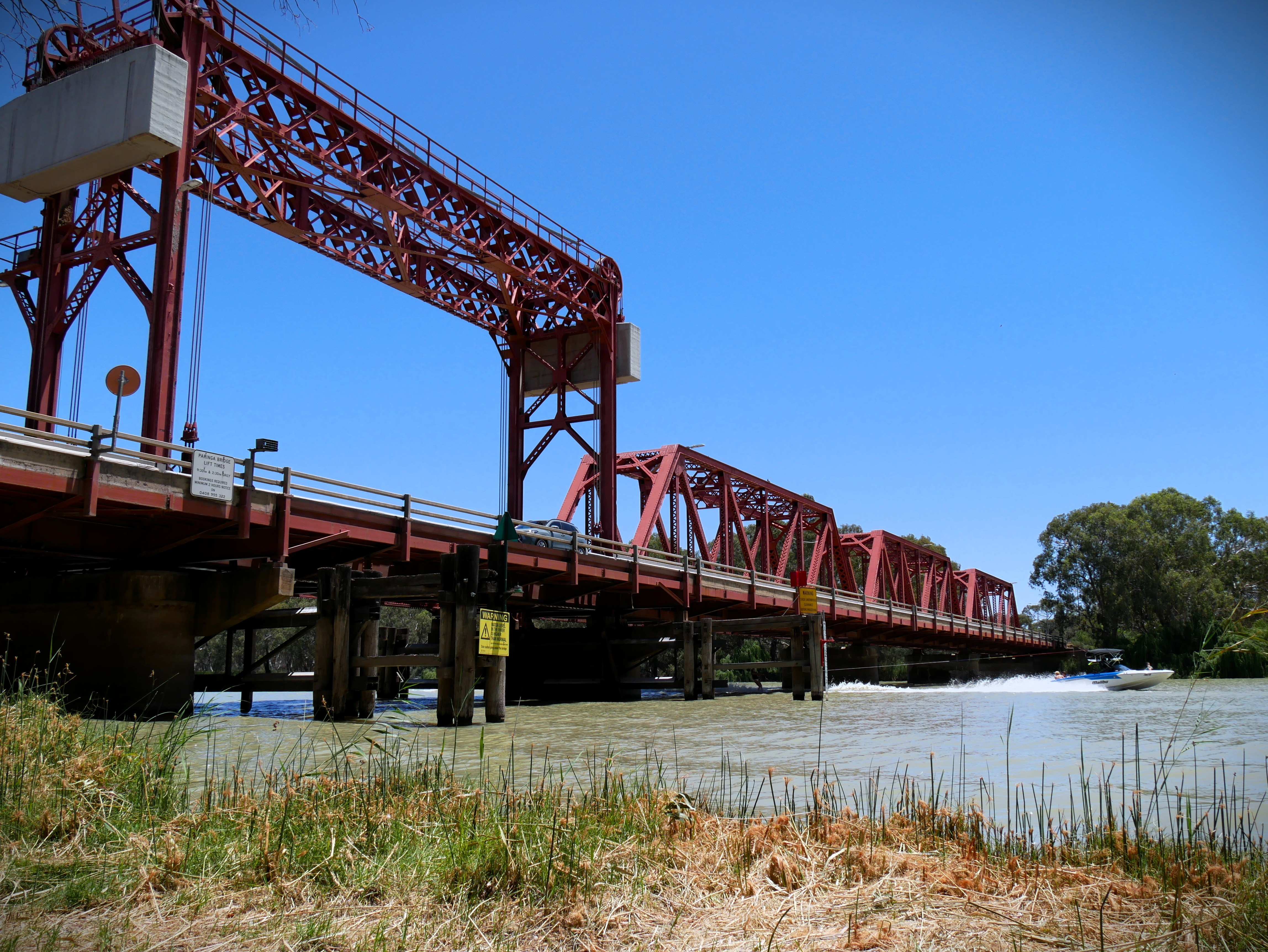 Ponte vermelha com barco abaixo. 