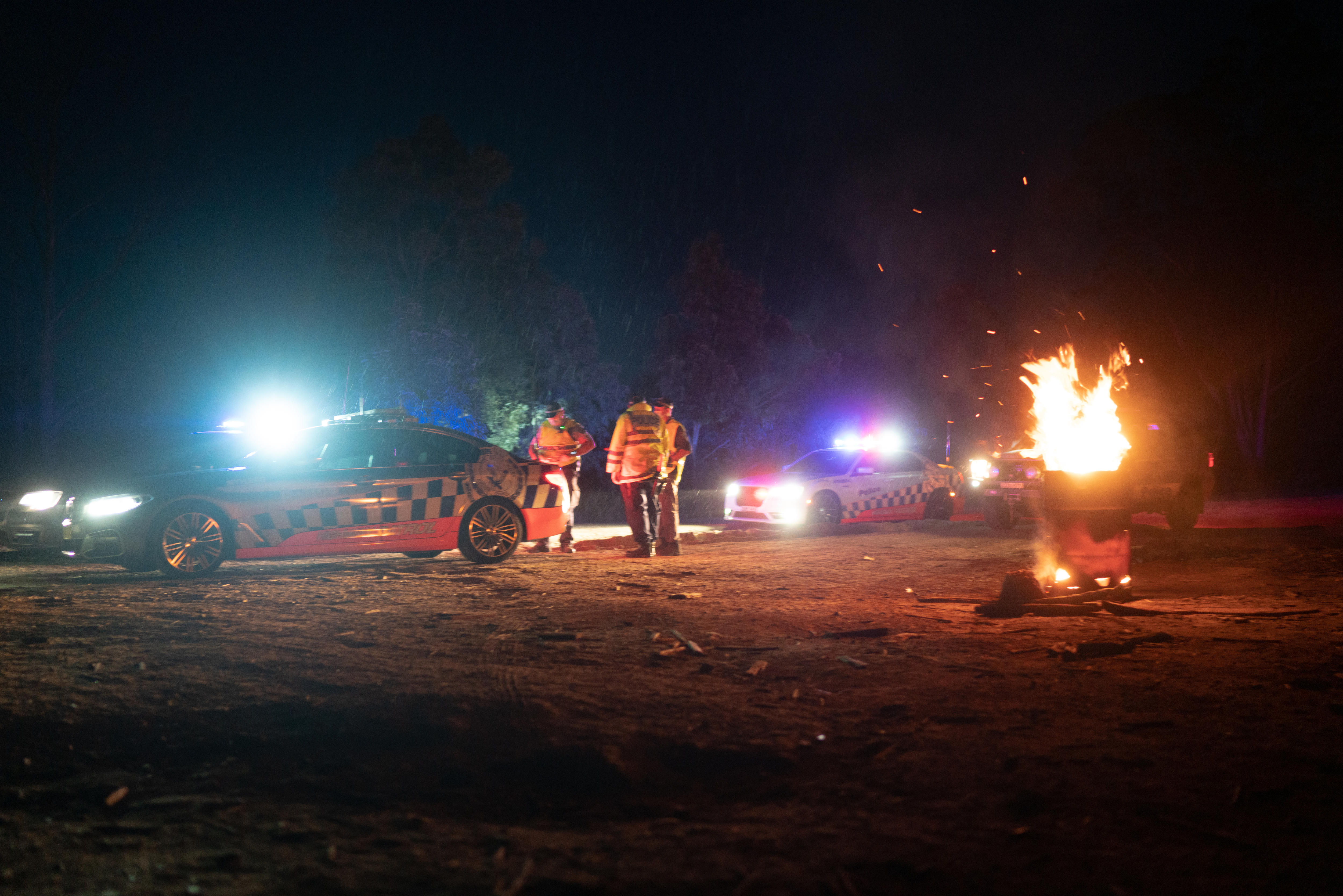 A fire burning in front of a police car