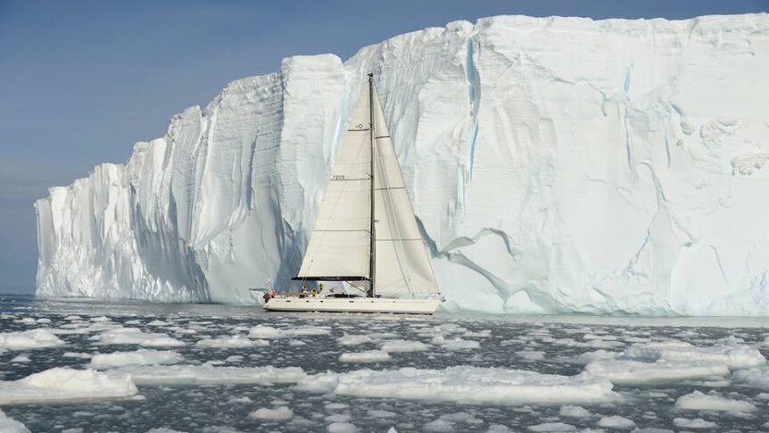 Katharsis II pictured next to Antarctic iceberg.