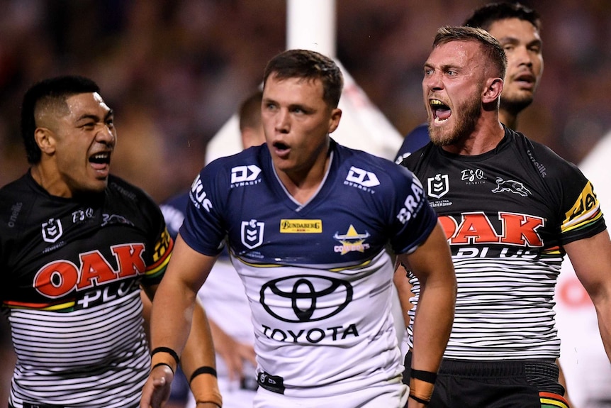 Penrith Panthers player Kurt Capewell screams in delight as North Queensland Cowboys player Scott Drinkwater looks sad.