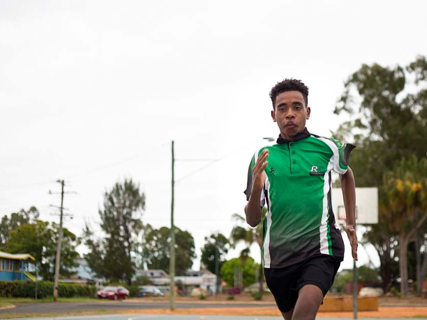 Teenager sprinting across basketball court.