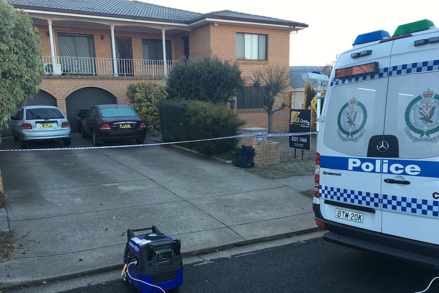 A police van outside a house, police tape