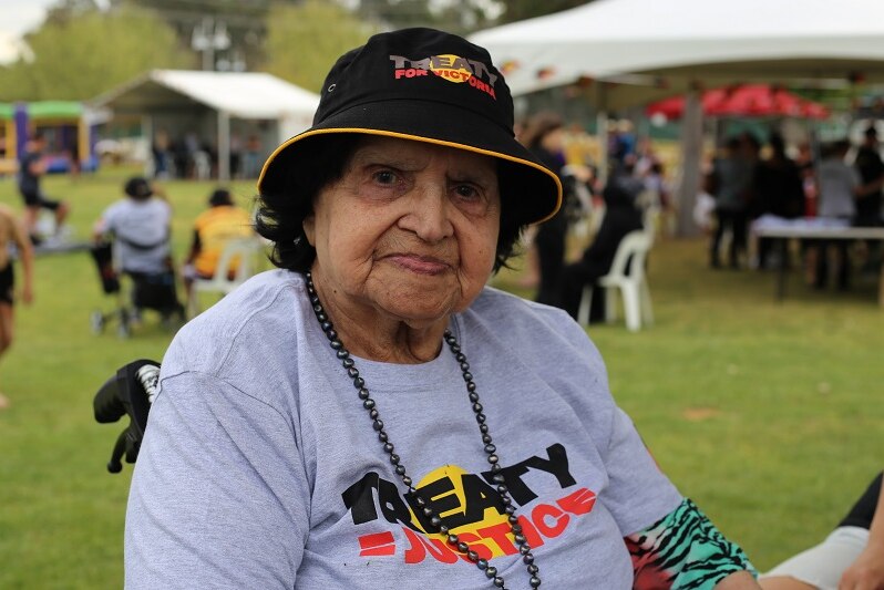 Aunty Frances Mathyssen looks pensively at the camera as she sits in her wheelchair wearing a Treaty t-shirt.