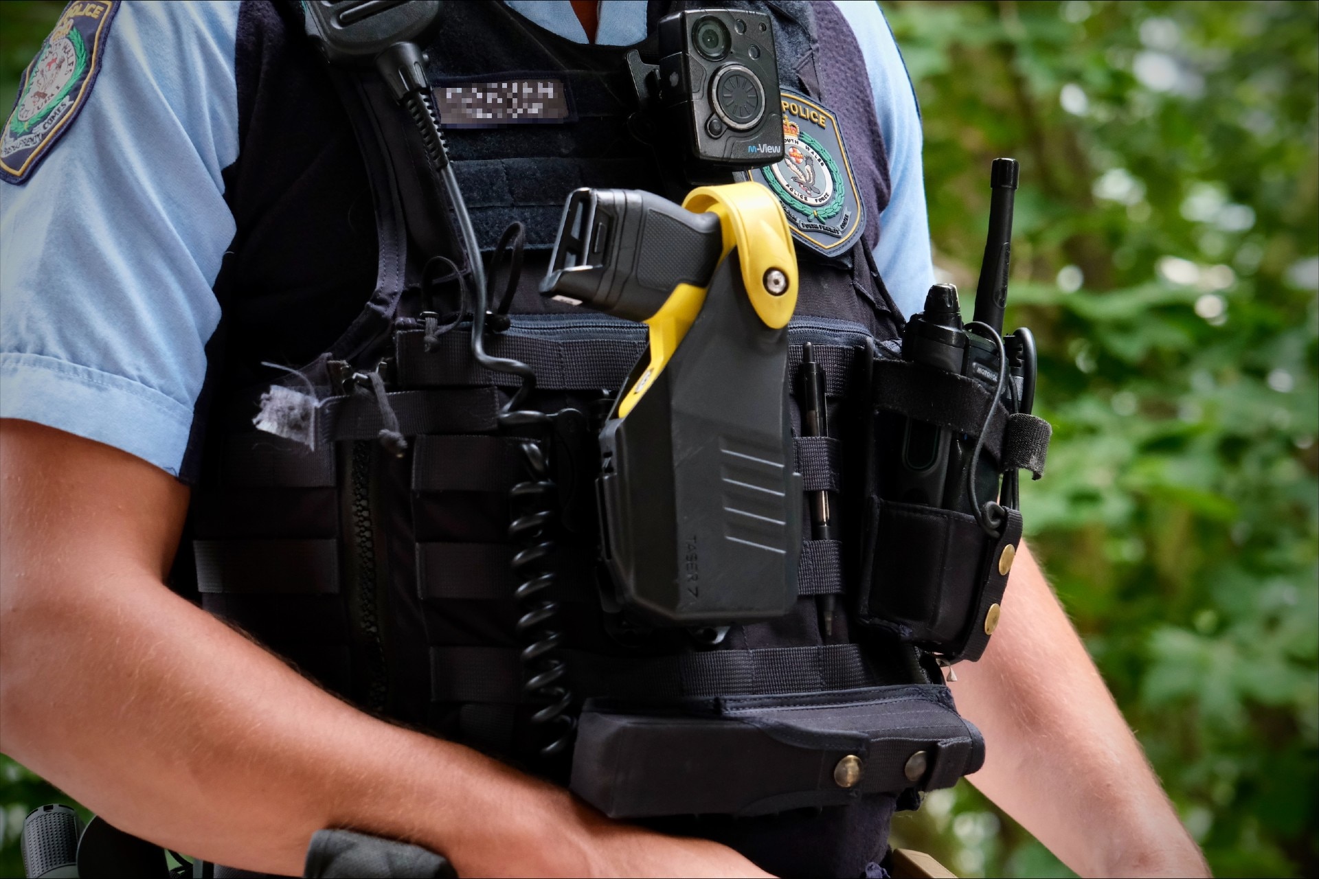 Torso of person in police uniform with a holstered taser attached to their vest.