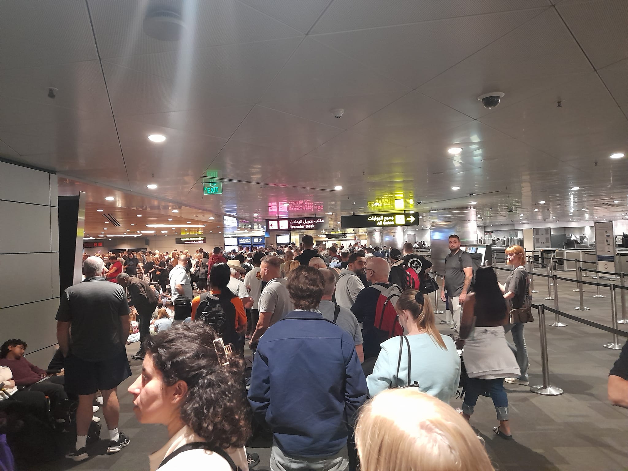Crowds mill about a crowded airport terminal.