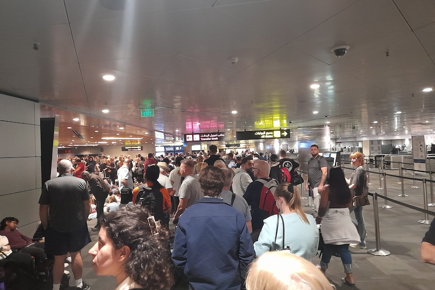 拥挤的机场航站楼周围挤满了人群。