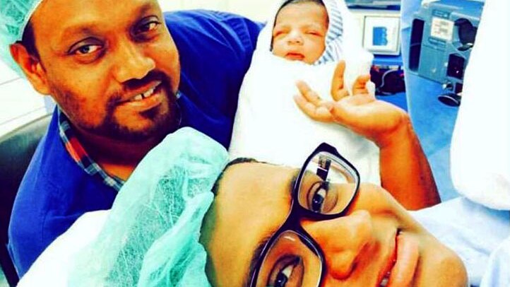 Shizleen Aishath in the delivery room with her husband and baby Kayban.
