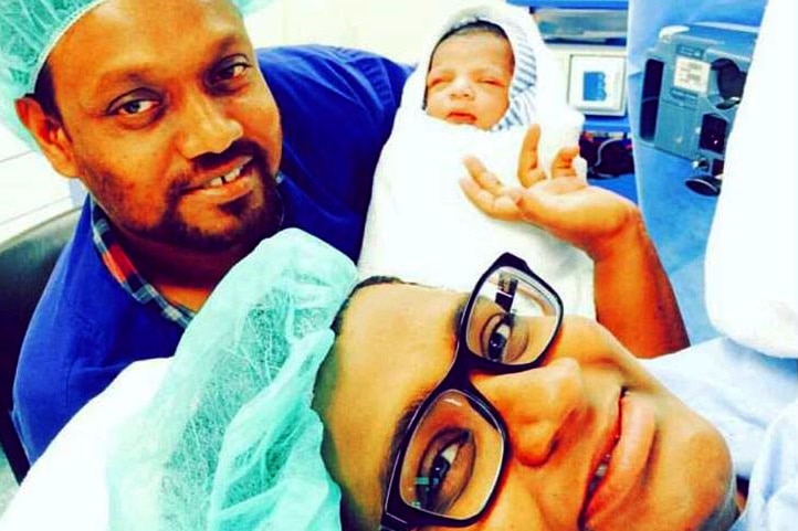 Shizleen Aishath in the delivery room with her husband and baby Kayban.