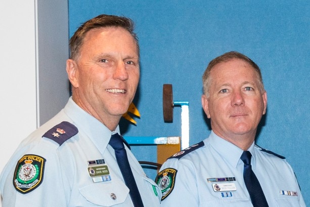 three police officers handing over an $80,000 cheque from the Police Bank