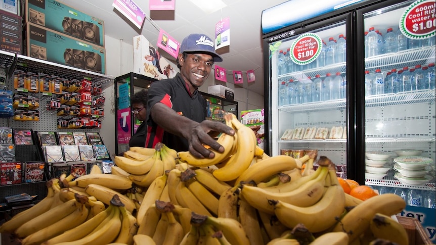 a person stacking banans in a store