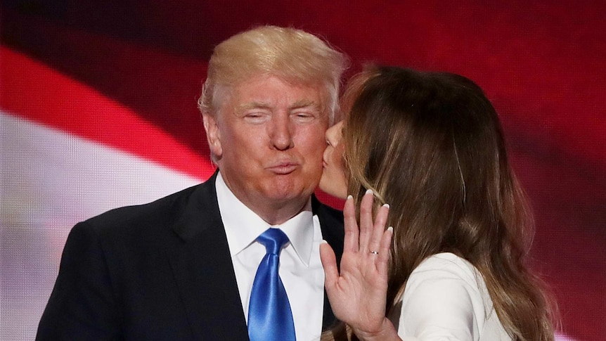 Donald Trump stands with wife Melania Trump on stage