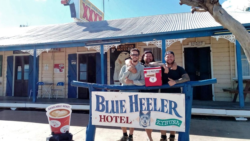 Three mates standing outside the Blue Heeler Hotel in Kynuna.