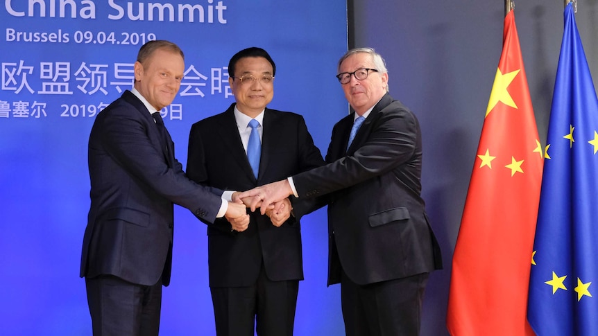 Chinese Premier Li Keqiang (centre) is welcomed by European Council president Donald Tusk with a hand clasp.