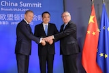 Chinese Premier Li Keqiang (centre) is welcomed by European Council president Donald Tusk with a hand clasp.