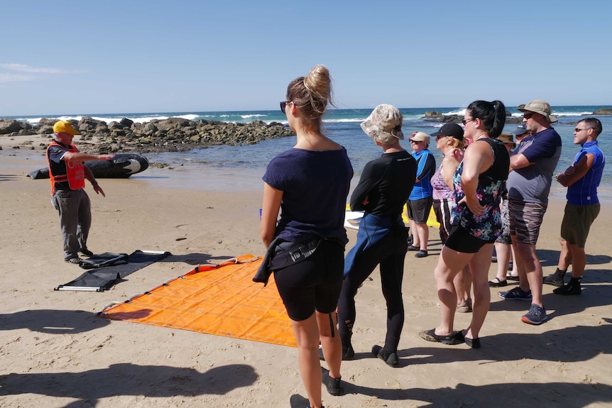 ORRCA instructor Leigh Mansfield on the beach speaking to the volunteers