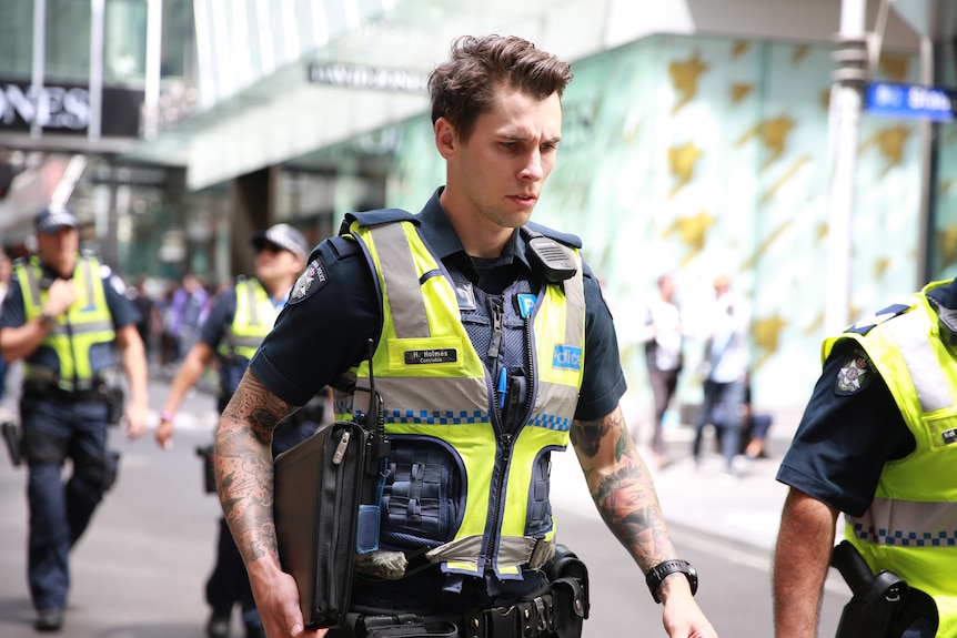 Four police officers walk down Little Bourke Street in Melbourne.