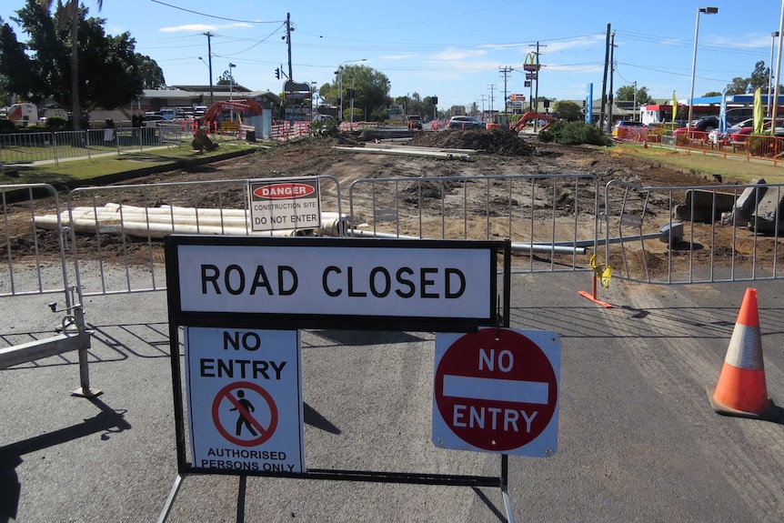 The road is completely dug up and a Road Closed sign stands in front.