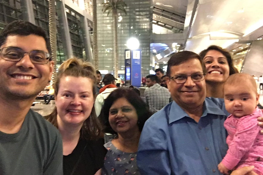 A family smiling at the airport.