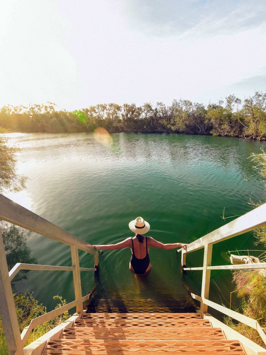 woman descending steps into water.