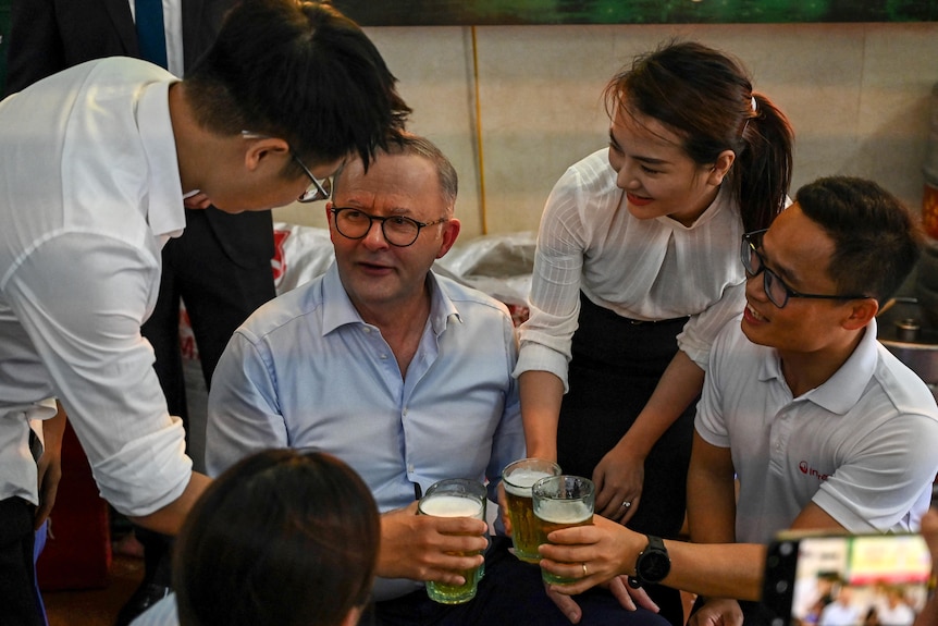 Australia's Prime Minister drinking beer with a group of people in Vietnam, Hanoi. 