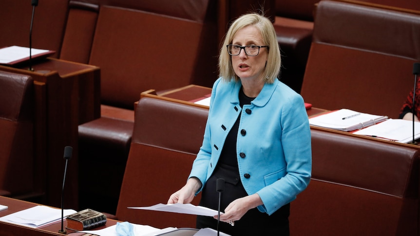 Woman wearing a blue jacket speaking in the Australian Senate chamber. 