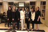 Kim Kardashian West stands in the middle of six women for a photo inside a lobby